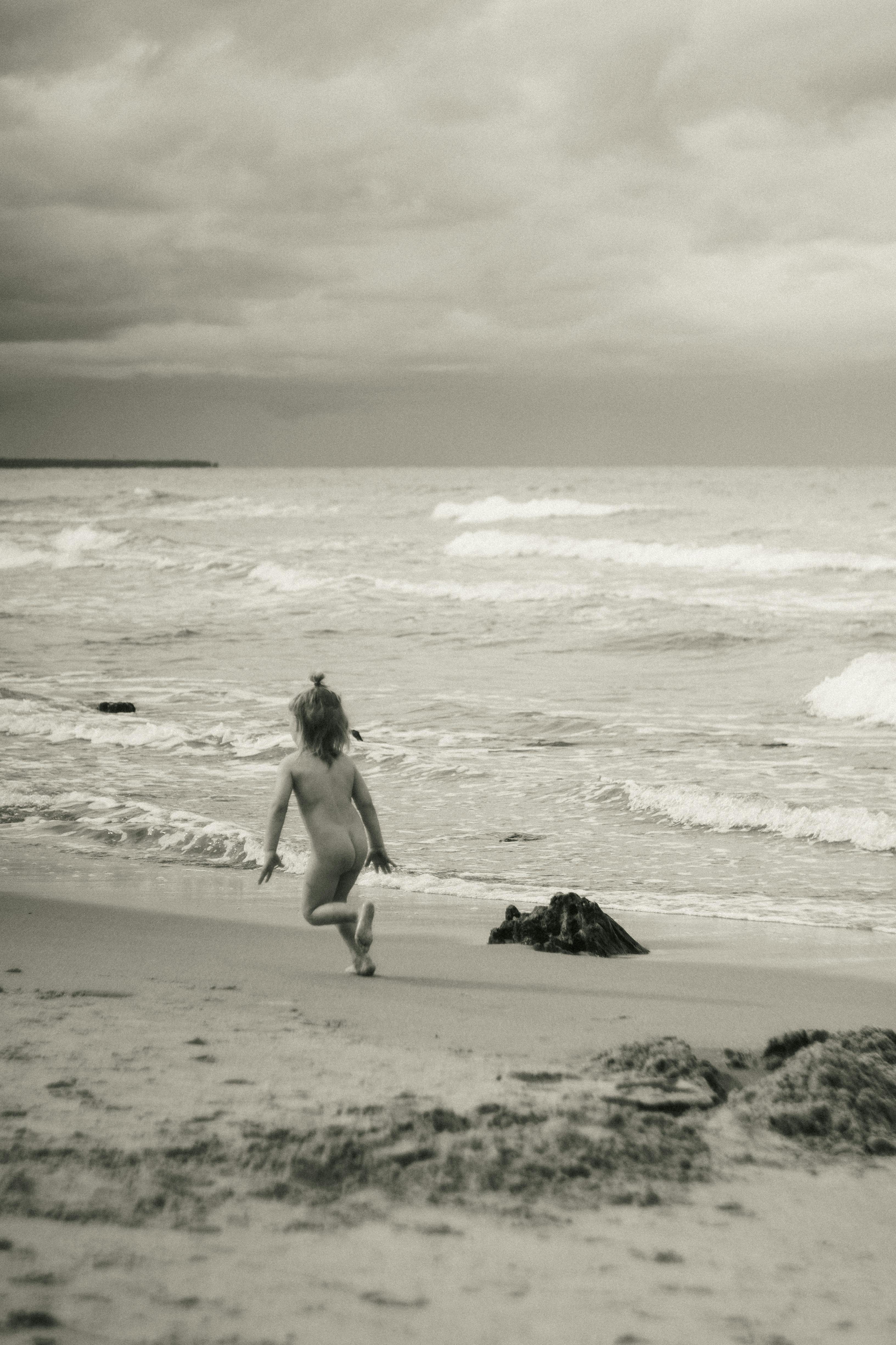Naked girl running in water